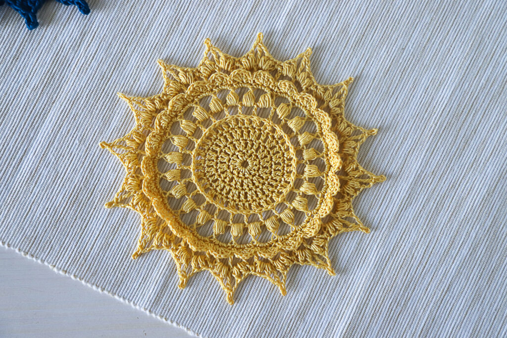 Yellow crochet coaster Tatiana designed by Olga Shalaeva, 14 cm